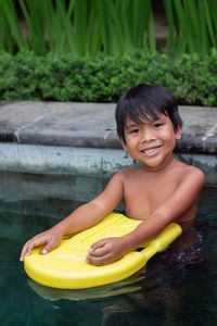 Portrait of cute boy playing with swimming board