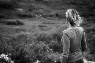 Rear view of woman standing on field