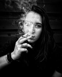 Close-up portrait of young woman smoking