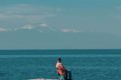 Rear view of person looking at sea against sky