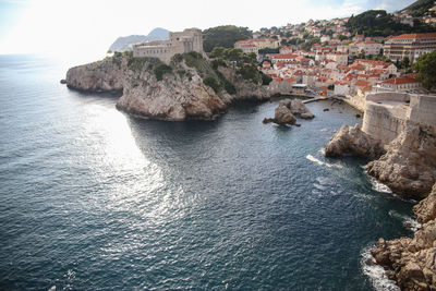 Scenic view of sea by cliff against sky