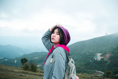 Beautiful woman standing on mountain against sky