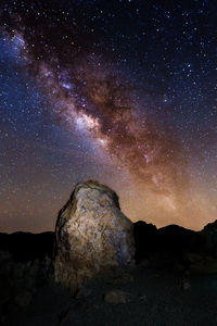 Rock formations against sky at night