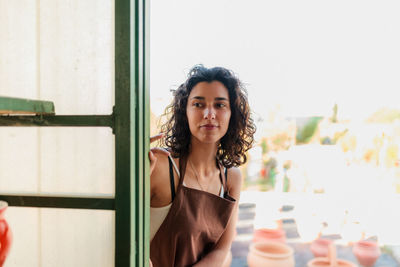 Young woman standing at entrance of workshop