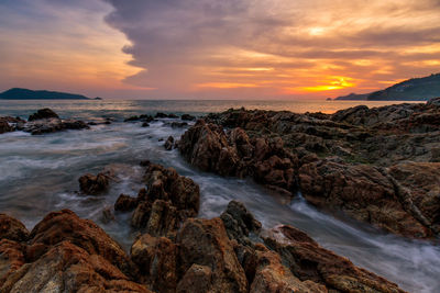 Rocks on sea shore at sunset