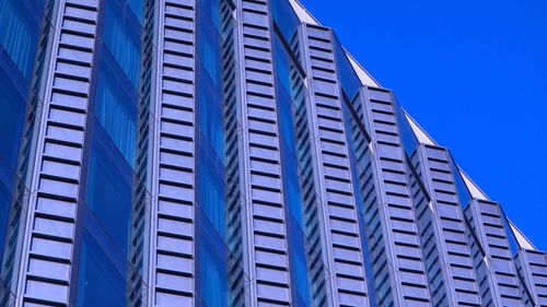 Low angle view of modern building against clear blue sky