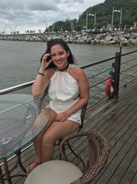 Portrait of smiling young woman sitting on boat sailing in river