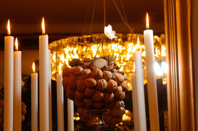 Atmospheric candle light with a walnut sculpture and chandelier in the background