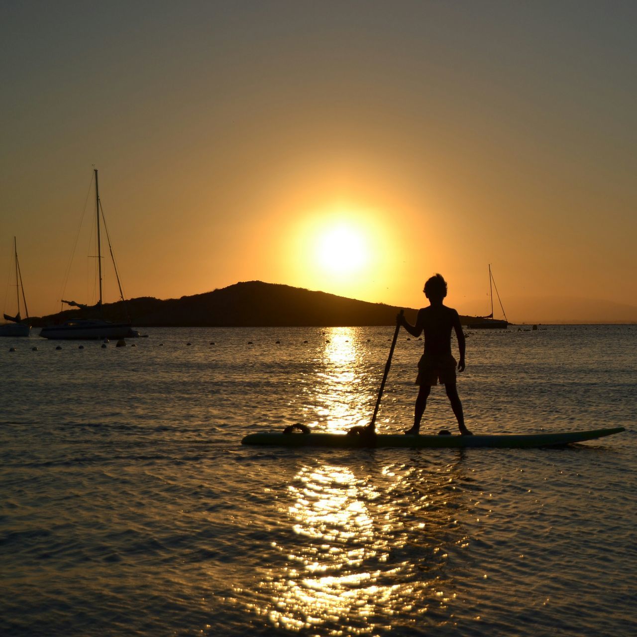 sunset, water, sun, silhouette, orange color, sea, leisure activity, reflection, lifestyles, men, scenics, beauty in nature, tranquil scene, nature, sky, tranquility, nautical vessel, sunlight