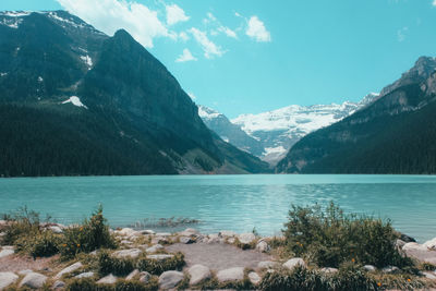 Scenic view of lake by mountains against sky