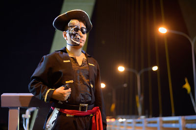 Young man wearing pirate costume standing against sky at night