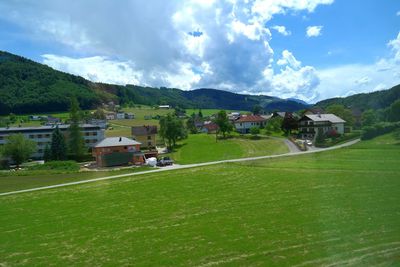 High angle view of green landscape against houses