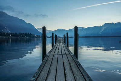 Wooden pier over lake against sky