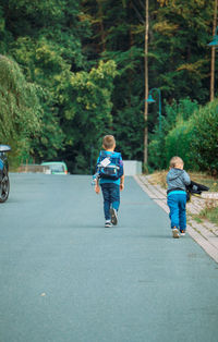 A boy with a satchel returns home from school