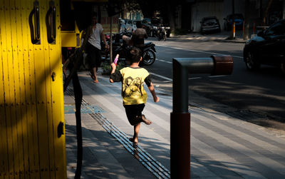 People running on sidewalk in city