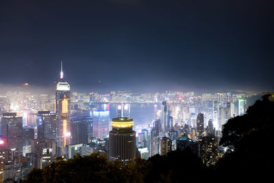 Illuminated cityscape against sky at night