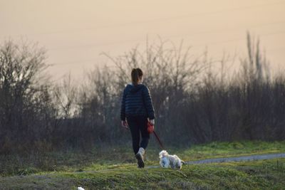 Full length rear view of child with dog