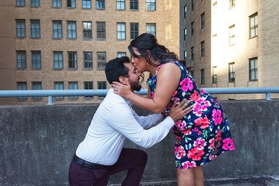 Side view of couple standing against the wall