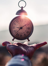 Close-up of hand holding clock