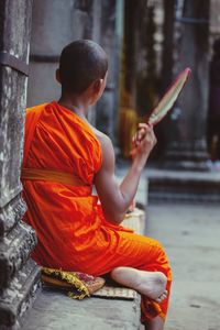 Full length of man sitting outside building