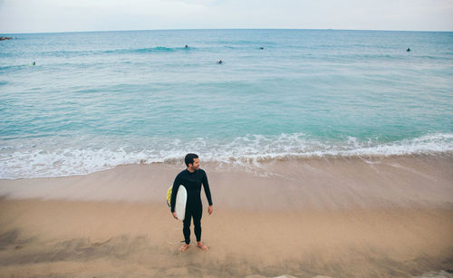 Full length of man standing on beach against sky