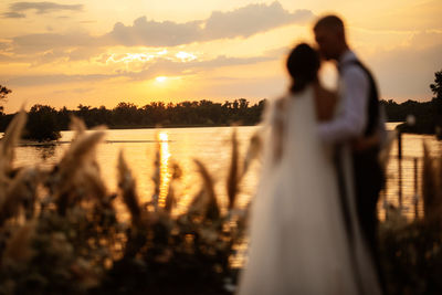 Rear view of woman standing at sunset