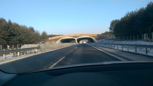 Car moving on road against clear sky