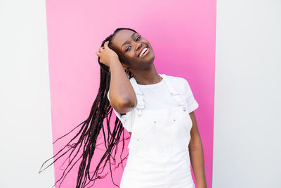 Portrait of young woman standing against white background