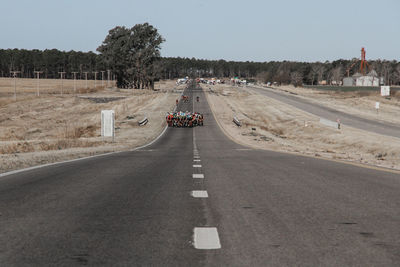 Vehicles on road against clear sky