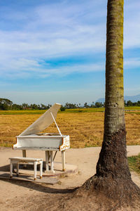 Piano on beach against sky