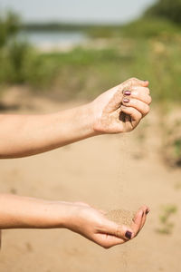 Close-up of man hand on sand