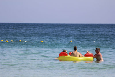 People enjoying in sea against sky