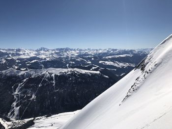 Aerial view of snowcapped mountains against clear sky