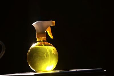 Close-up of spray bottle on table in darkroom