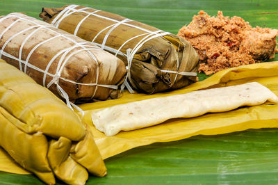 Burasak and nasu likku or steam rice in banana leaf with chicken galangal rendang.