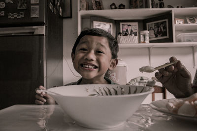 Portrait of happy boy holding ice cream in bowl