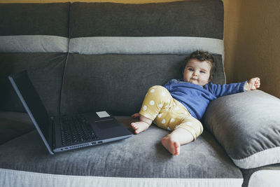 Portrait of man using mobile phone on sofa at home