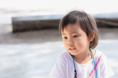 Asian girl, little toddler child with adorable short hair looking at copy space. absent minded.