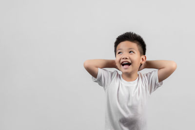 Portrait of boy standing against white background