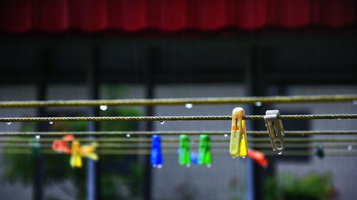 Colorful clothespins hanging on wet rope