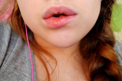 Midsection of woman with braided hair puckering lips