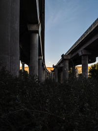 Low angle view of old bridge amidst buildings against sky