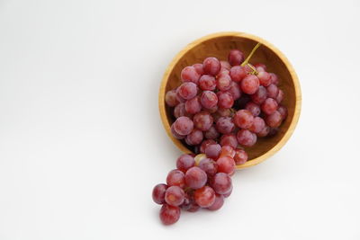 Directly above shot of grapes in bowl against white background