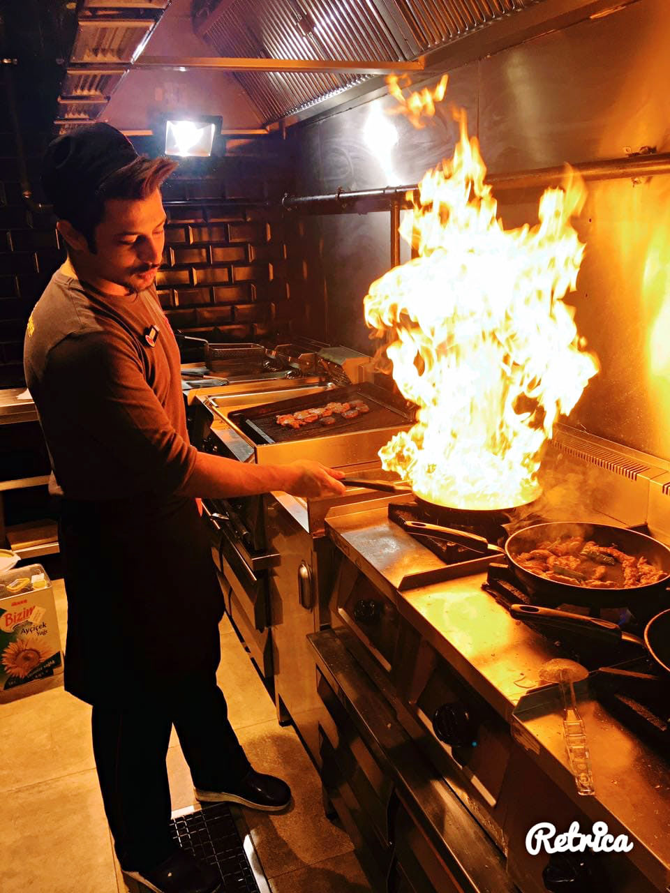 MIDSECTION OF MAN HAVING FOOD AT KITCHEN