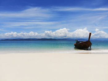 Blue sky with cloud beautiful sea white sand beach with wooden boat at southern sea thailand summer 