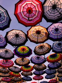 Low angle view of multi colored umbrellas in city