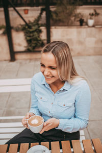 Young woman drinking coffee cup on table