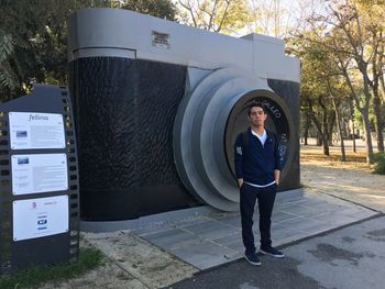 Portrait of young man standing against trees