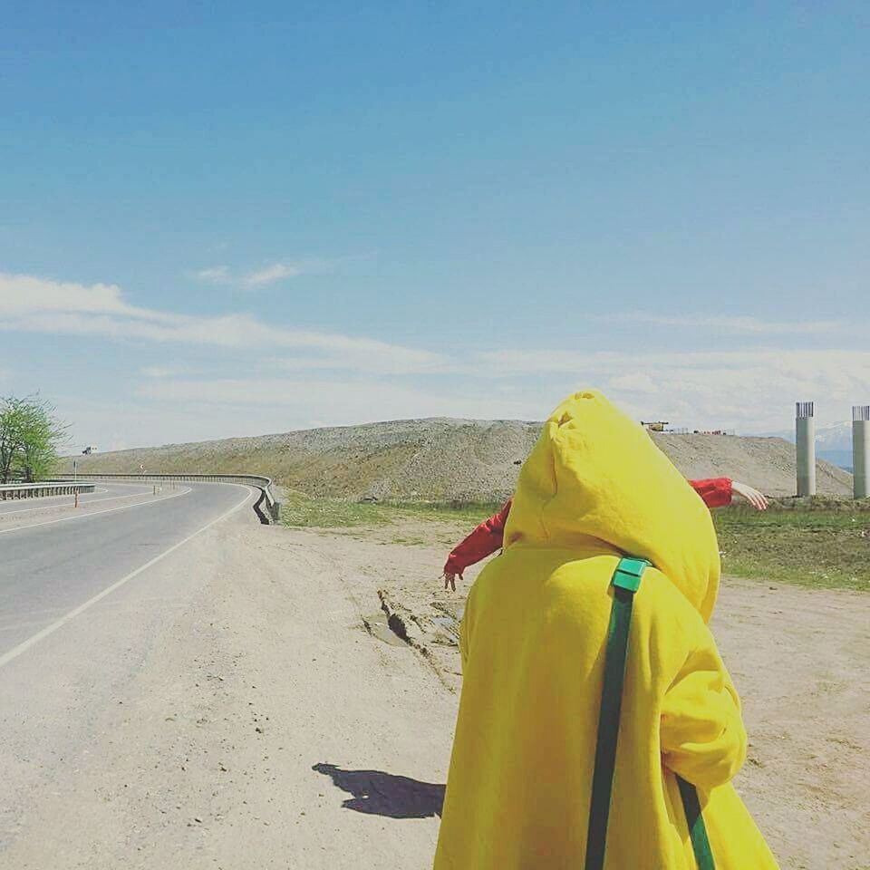 REAR VIEW OF A WOMAN ON YELLOW ROAD