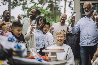 Multi-generation family cheering for boy during birthday celebration